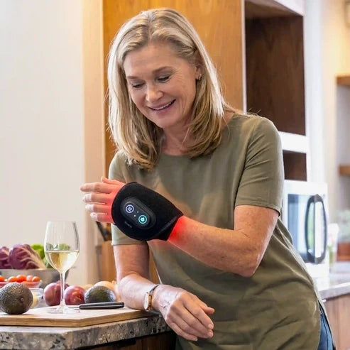 Woman wearing the CiraWrap heated wrist massager during an everyday kitchen routine